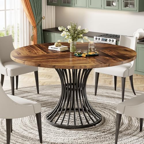A Tribesigns round dining table with a rustic brown finish and a black hourglass-shaped metal base styled in a contemporary dining room.
