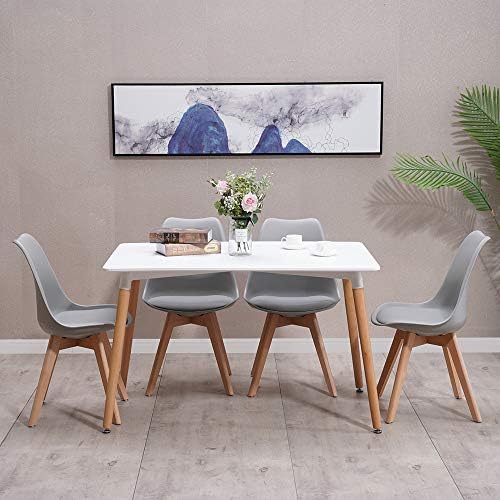 A modern rectangular dining table with a white top and solid wood legs surrounded by four grey PU leather chairs in a bright room.